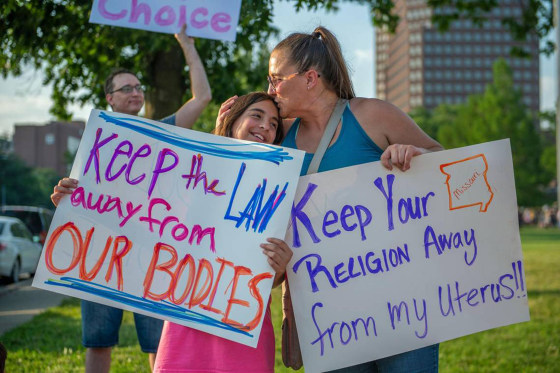 Eleven-year-old Giuliana Cangelosi, left, and her mother Nichole Cangelosi share a moment together while attending a protest opposing the Supreme Court's ruling overturning federal protections for abortion rights June 24, 2022, in Mill Creek Park at Country Club Plaza in Kansas City, Missouri. 